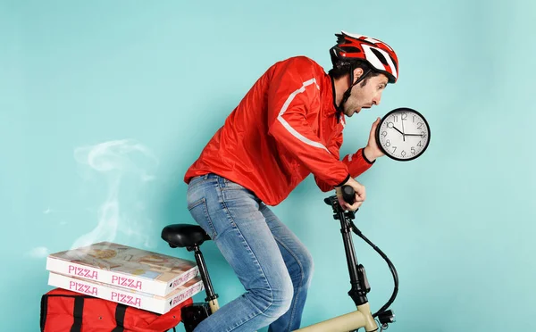 Lieferant rast mit Elektrofahrrad zur Pizza-Lieferung und vermeidet Verzögerungen — Stockfoto