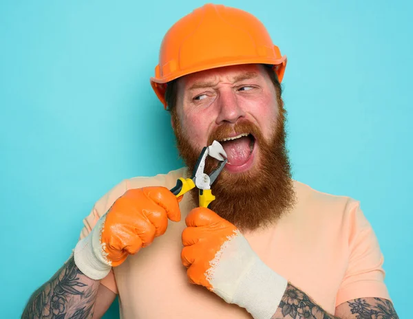 Incompetent worker acts like a dentist and removes a tooth. cyan background — Stock Photo, Image