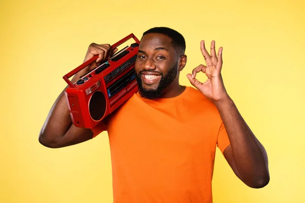 Man ears the music with an old stereo and dances. emotional and energetic expression. yellow background