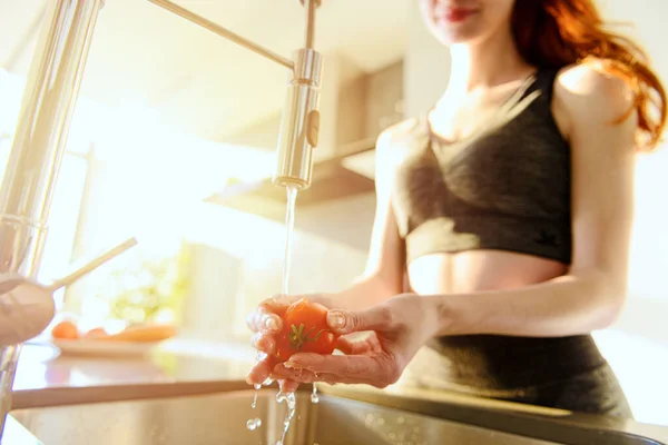 Fitness kadını taze domatesi lavaboda duruluyor. — Stok fotoğraf