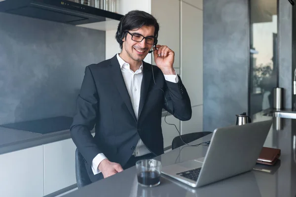 Empresario con auriculares en una videoconferencia desde su ordenador personal — Foto de Stock