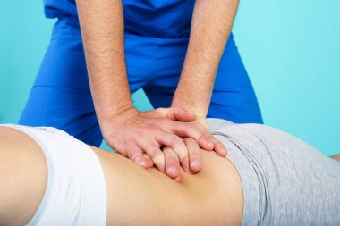 Kız bir fizyoterapistle egzersiz yapıyor. Cyan arkaplanı
