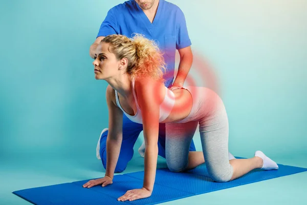 Girl performs exercises with a physiotherapist. Cyan background — Stock Photo, Image