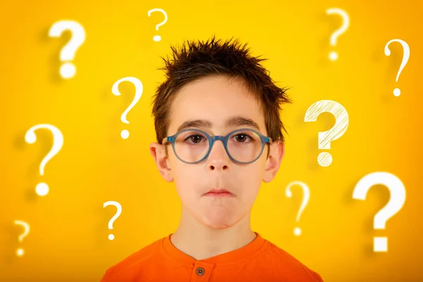 아이는 무엇인가를 확실 히모르며 몇 가지 질문이 있다. 노란 배경 — 스톡 사진