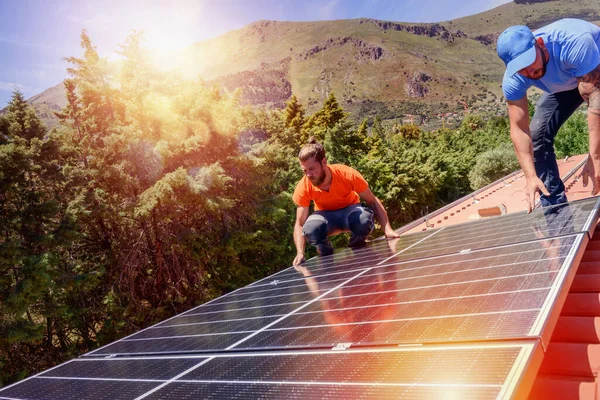 Arbeiter montieren Energiesystem mit Solarzellen für Strom und Warmwasser — Stockfoto