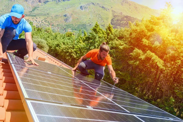 Os trabalhadores montam sistema de energia com painel solar para eletricidade e água quente — Fotografia de Stock