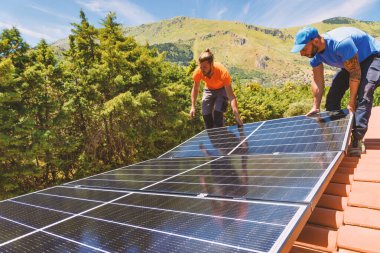 İşçiler enerji sistemini elektrik ve sıcak su için güneş paneliyle birleştiriyor