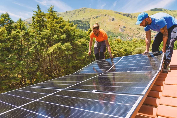 工人们用太阳能电池板组装供电和热水用的能源系统 — 图库照片