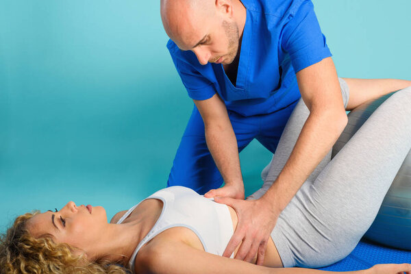 Девушка выполняет упражнения с физиотерапевтом. Цянь