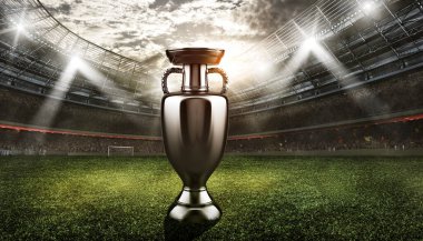 Futbol stadyumunun ortasında şampiyonluğu kazanan takım kupası.