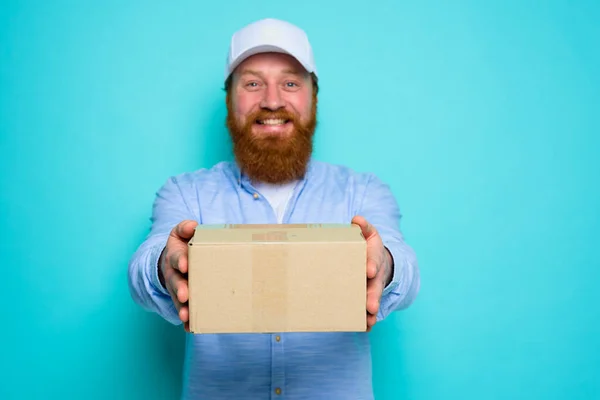 Mensajero con sombrero está feliz de entregar una caja de cartón —  Fotos de Stock