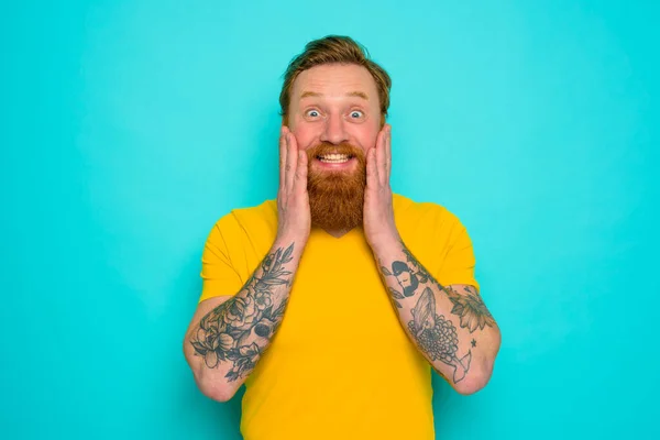 Man with yellow t-shirt and beard is very happy — Stock Photo, Image
