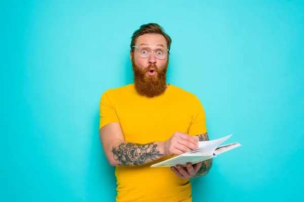 Homme avec t-shirt jaune et barbe est surpris de quelque chose — Photo