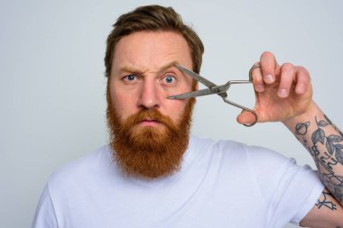 Makasla ciddi bir adam sakalı kesmeye hazır.