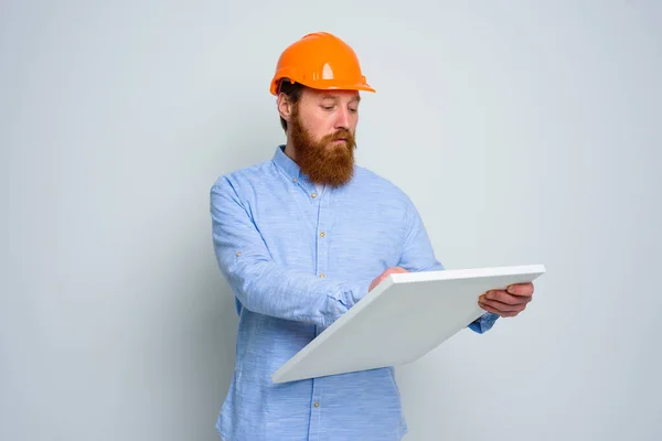 Arquiteto confiante com barba e capacete laranja faz um esboço — Fotografia de Stock