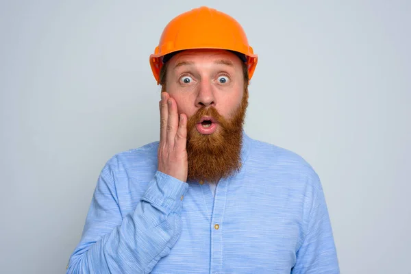 Isolado arquiteto surpreso com barba e capacete laranja — Fotografia de Stock