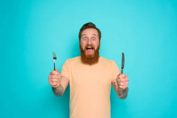 문신을 한 행복 한 남자는 손에 칼을 들고 식사할 준비가 되어 있다 — 스톡 사진
