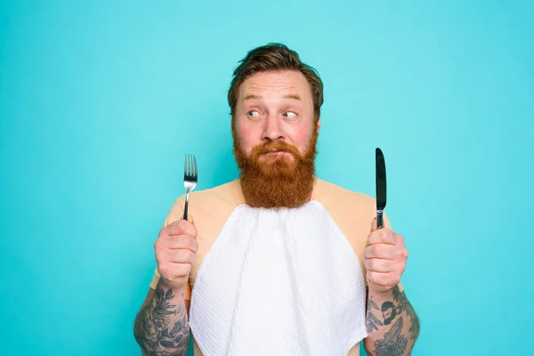 Homme tatoué est prêt à manger avec des couverts à la main — Photo