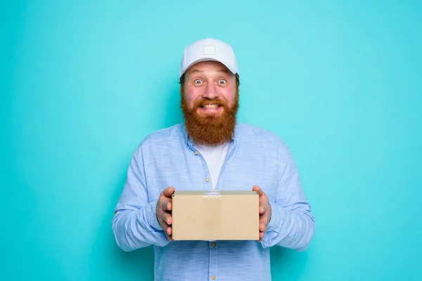 Mensajero con sombrero está feliz de entregar una caja de cartón — Foto de Stock