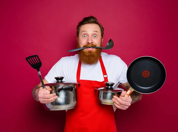 Confused chef with beard and red apron is ready to cook — Zdjęcie stockowe