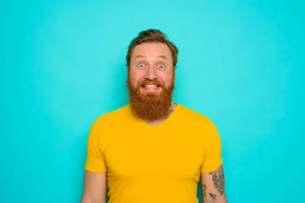 Muž se žlutým tričkem a vousy je velmi šťastný — Stock fotografie