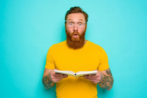 Homme avec t-shirt jaune et barbe est surpris de quelque chose — Photo