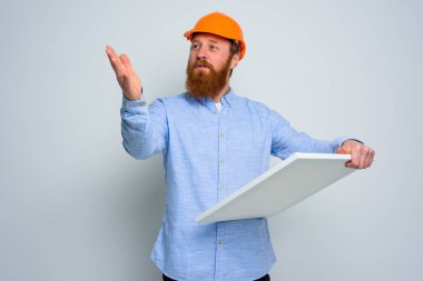 Sakallı ve turuncu kasklı sırdaş bir mimar eskiz çiziyor.