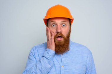 Sakallı, turuncu kasklı, şaşırmış bir mimar.
