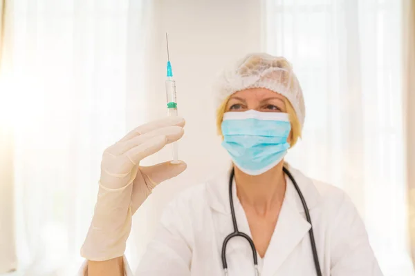 Лікар з маскою і шприцом готовий вводити вакцину проти ковадла 19 — стокове фото
