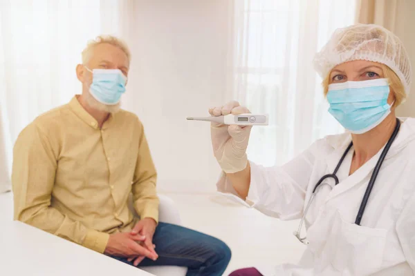 Doctor está perdiendo la temperatura del paciente —  Fotos de Stock