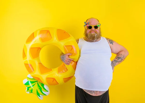 Fat delusion man with wig in head is ready to swim with a donut lifesaver — Stock Photo, Image
