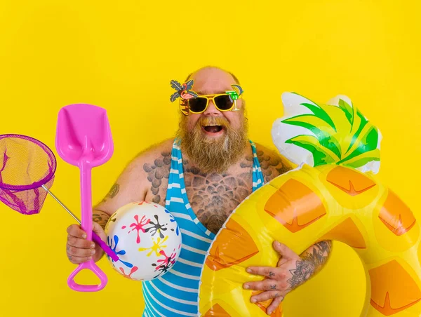 Gros homme heureux avec une perruque à la tête est prêt à nager avec un sauveteur de beigne — Photo