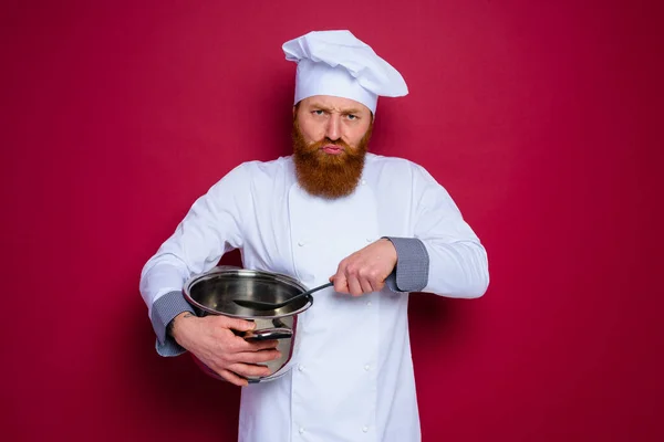 수염을 기르고 빨간 앞치마를 입은 불행 한 요리사가 요리를 할 준비가 되어 있다 — 스톡 사진