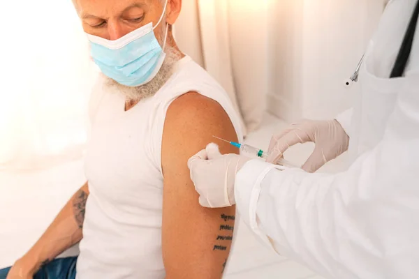 Лікар вводить вакцину проти ковадла-19 пацієнту з шприцом — стокове фото