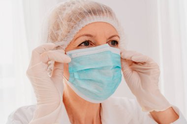 Doktor maskesini, kendini kovid 19 virüsüne karşı koruyacak şekilde ayarla.