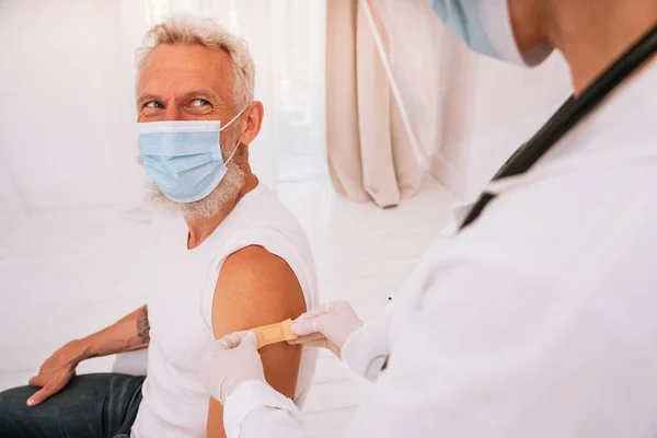 Лікар наносить латку пацієнту після вакцини проти ковадла-19 — стокове фото