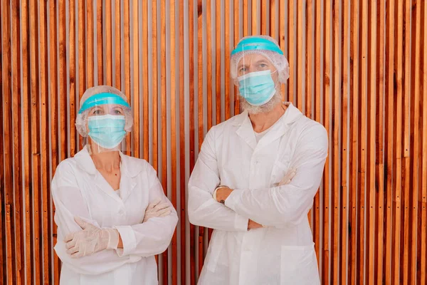 Médicos con máscara y protector facial están listos para trabajar en el hospital —  Fotos de Stock