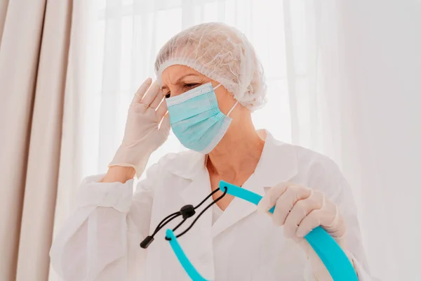 Dokter met gezichtsmasker en gezichtsbeschermer is moe van de covid-19 virus pandemie — Stockfoto
