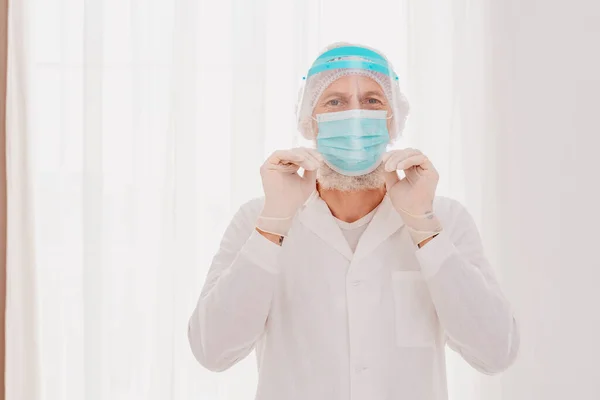 Dokter met masker en gezichtsbeschermer is klaar om te werken in het ziekenhuis — Stockfoto