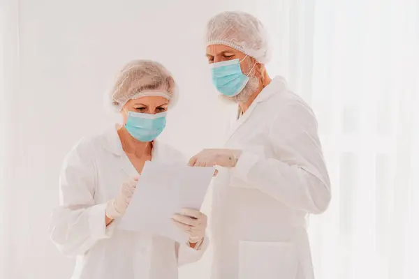 Médicos com máscara facial trabalham juntos no hospital — Fotografia de Stock