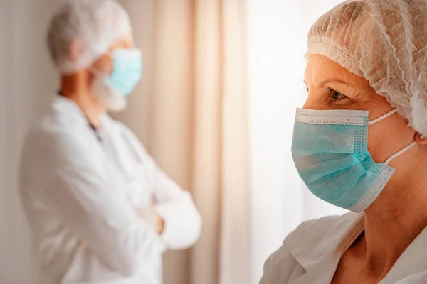 Médicos con máscara facial piensan que están listos para trabajar —  Fotos de Stock