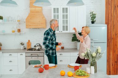 Karı koca kahvaltıda evde dans ediyorlar.