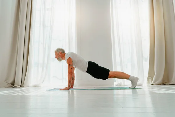 Sportif adam evde yoga egzersizi yapıyor. — Stok fotoğraf