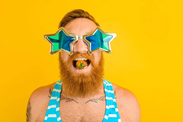 Uomo con barba e occhiali da sole mangia una fragola — Foto Stock
