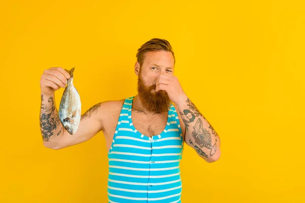 Uomo con barba e costume da bagno catturato un pesce — Foto Stock