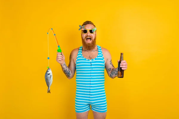 Mężczyzna z brodą i strojem kąpielowym złapał rybę — Zdjęcie stockowe