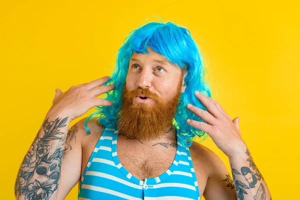 Uomo felice con boa di salvataggio, costume da bagno e parrucca blu si comporta come una donna felice — Foto Stock