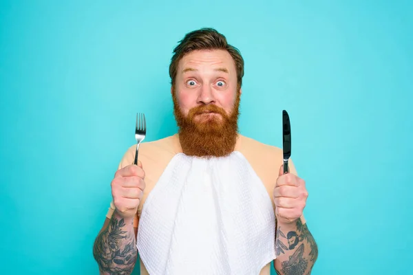 Ο άντρας με τα τατουάζ είναι έτοιμος να φάει με μαχαιροπήρουνα στο χέρι. — Φωτογραφία Αρχείου