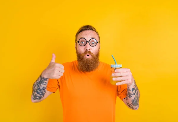 Nerd homme heureux avec des verres boit un jus de fruit — Photo