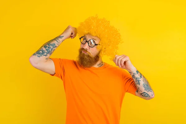 Thoughtful man with beard, yellow wig and glasses — Zdjęcie stockowe